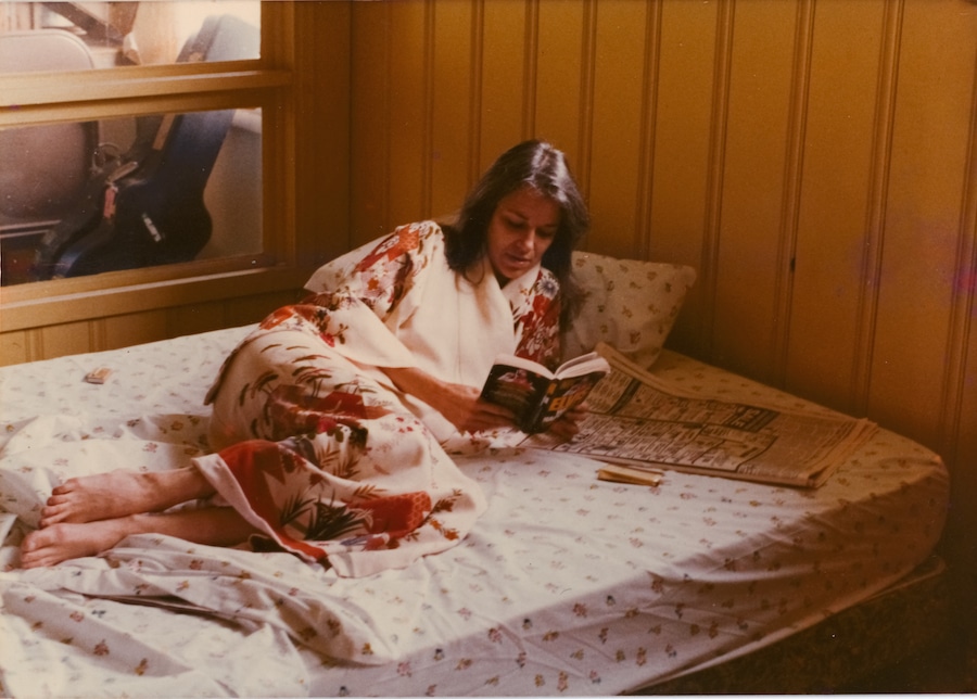 Susanna Clark relaxing in bed with a book and newspaper