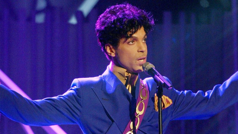 Prince, known for songs like "When Doves Cry," pictured performing onstage.