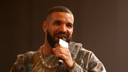 Drake pictured speaking into a microphone onstage at a rap battle.