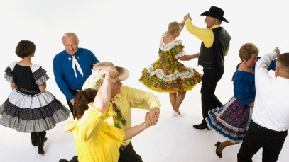 Several couples are square dancing together as they would to the song "Skip to My Lou."