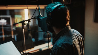 Male singer singing into a recording studio microphone.