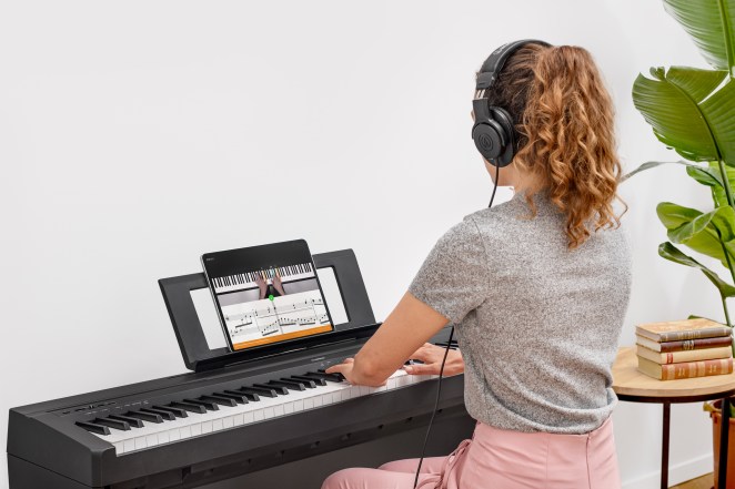 girl playing piano with flowkey