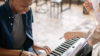 young man taking piano lessons