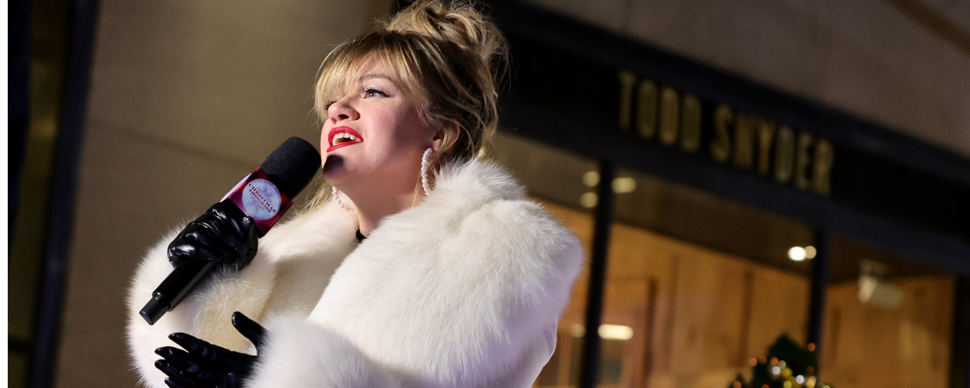 Kelly Clarkson Can’t Stop Grooving to Cher in “Adorable” Rockefeller Tree Lighting Video