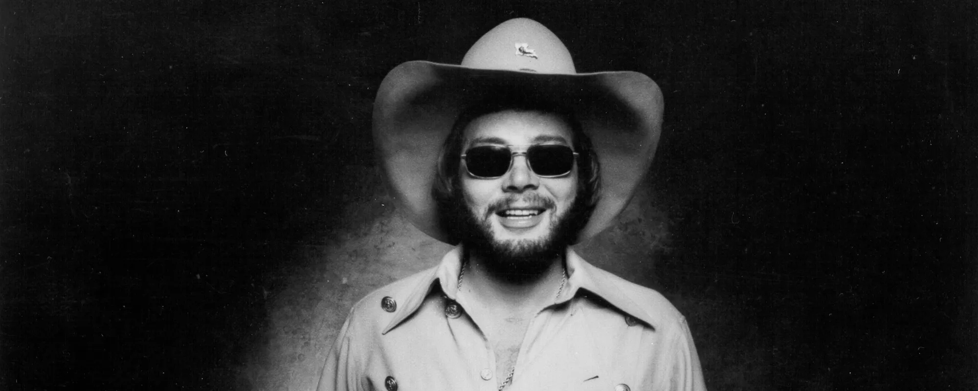 The Meaning Behind Hank Williams Jr.’s Mournful Drinking Song “Whiskey Bent and Hell Bound”