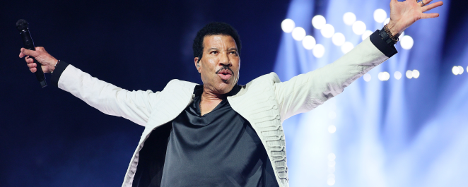 Lionel Richie onstage with arms outstretched