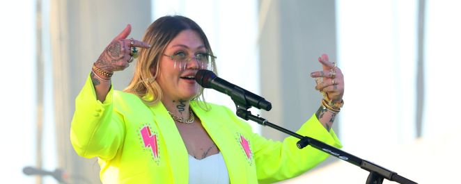 Elle King performs wearing a neon yellow jacket adorned with pink lightning bolts.