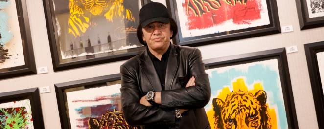 Kiss singer/bassist Gene Simmons poses in front of some of his works at the debut of Gene Simmons ArtWorks at Animazing Gallery at The Venetian Las Vegas on October 21, 2021 in Las Vegas, Nevada.