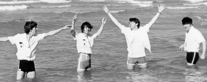 The Beatles standing in the ocean