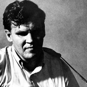 Doc Watson pose for a portrait with an acoustic guitar in circa 1968.