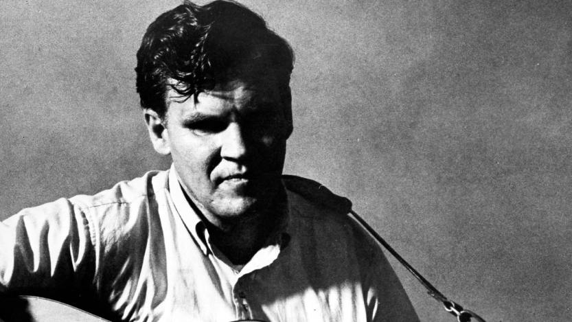 Doc Watson pose for a portrait with an acoustic guitar in circa 1968.