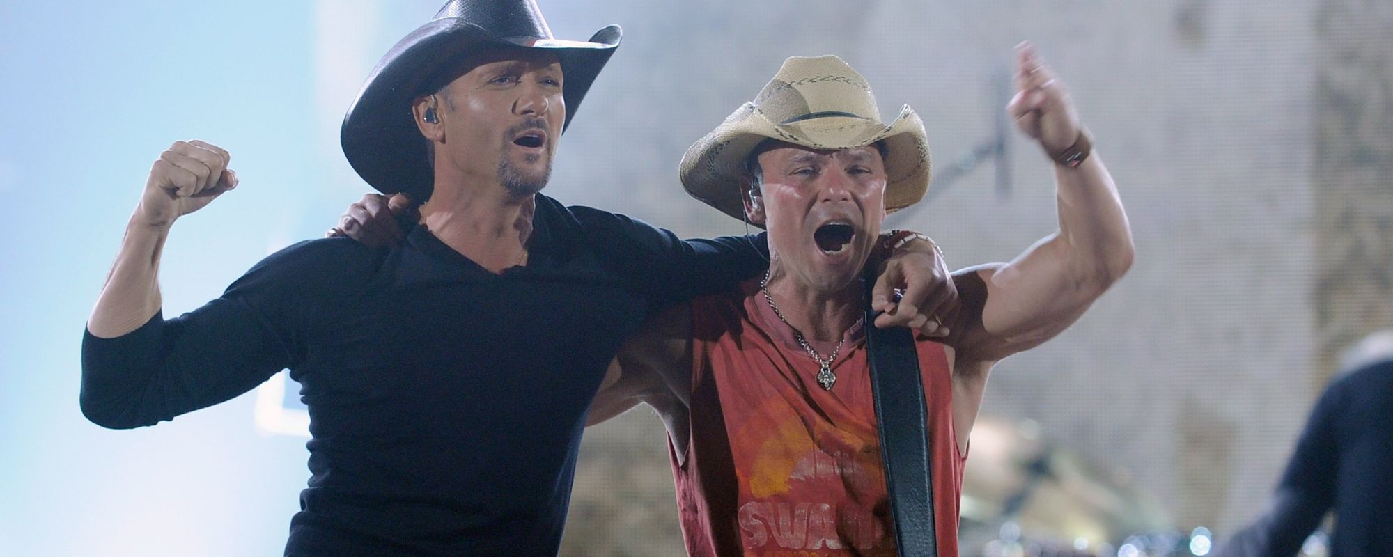 Tim McGraw and Kenny Chesney hug one another onstage