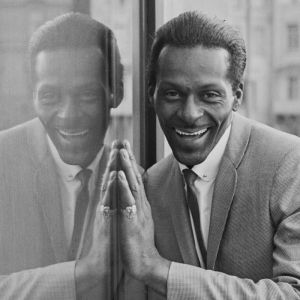 Chuck Berry smiling next to reflection of himself