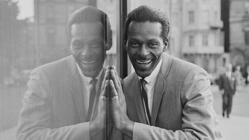 Chuck Berry smiling next to reflection of himself