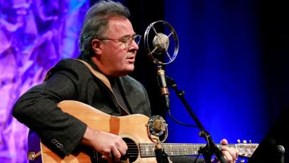 Country star Vince Gill playing an acoustic guitar.