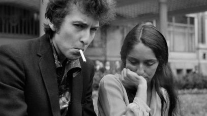 Bob Dylan and Joan Baez sit on bench together