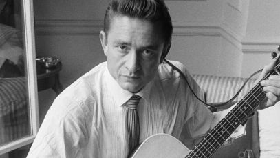 Johnny Cash sitting with guitar