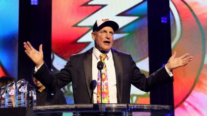 Woody Harrelson standing in front of Grateful Dead logo