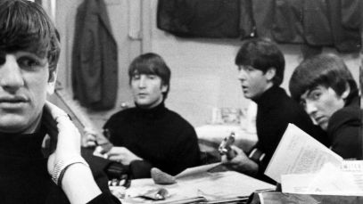 Ringo Starr sitting in front of rest of Beatles