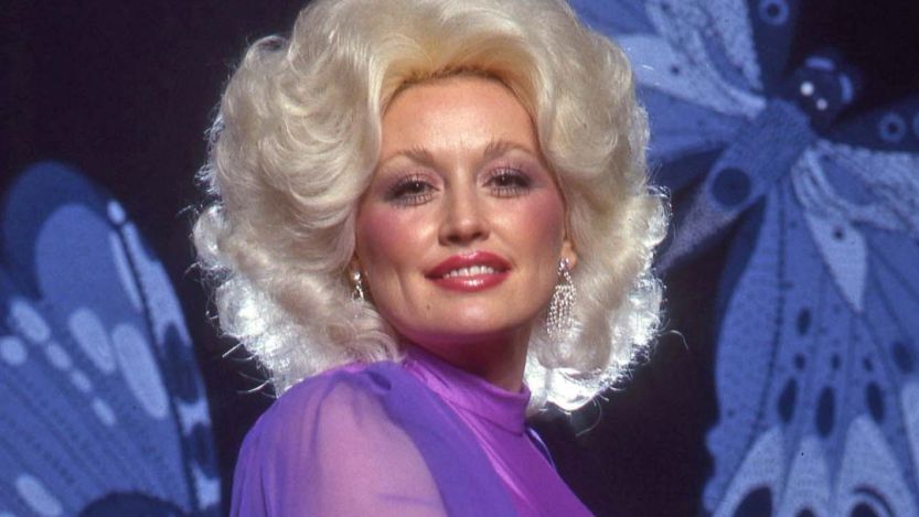 Dolly Parton posing in front of butterflies