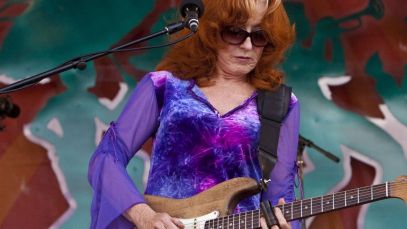 Bonnie Raitt performing, iconic guitarist known for not using complicated riffs