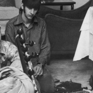 The Beatles watching George Harrison play the sitar