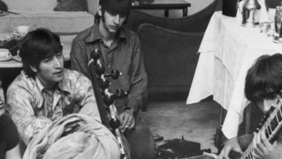 The Beatles watching George Harrison play the sitar