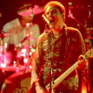 American Rock musician Billy Corgan, of the group Smashing Pumpkins. plays guitar as he performs onstage at the Metro, Chicago, Illinois, April 15, 1994. Visible behind him is bandmate Jimmy Chamberlin on drums. (Photo by Paul Natkin/Getty Images)