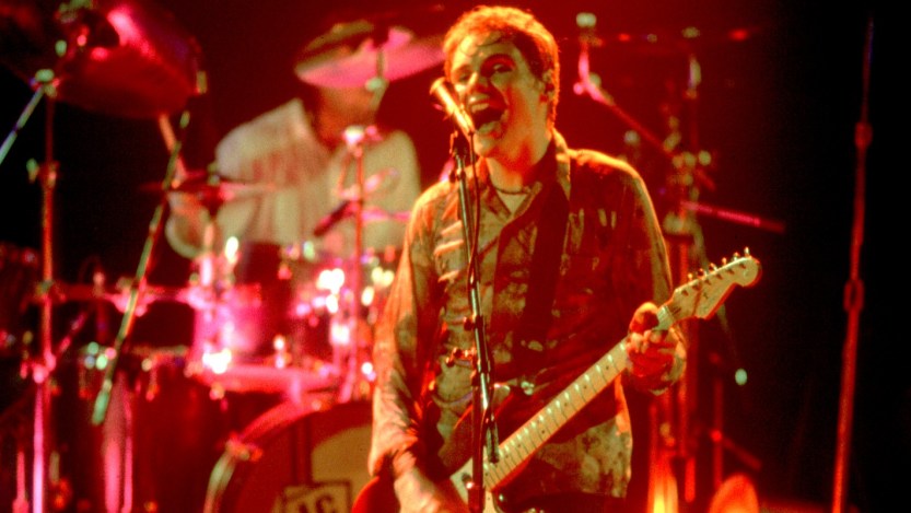 American Rock musician Billy Corgan, of the group Smashing Pumpkins. plays guitar as he performs onstage at the Metro, Chicago, Illinois, April 15, 1994. Visible behind him is bandmate Jimmy Chamberlin on drums. (Photo by Paul Natkin/Getty Images)