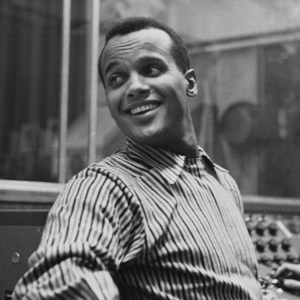 American singer-songwriter and civil rights activist Harry Belafonte, wearing a striped shirt, in an recording studio, circa 1957. The sound engineer is visible working at the console to the right of the frame. (Photo by Archive Photos/Hulton Archive/Getty Images)
