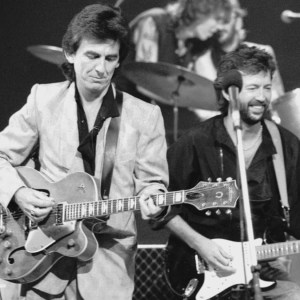 George Harrison (1943 - 2001, left) and Eric Clapton at Limehouse Studios in London during recording of the TV programme 'Blue Suede Shoes', spotlighting veteran rockabilly songwriter and guitarist Carl Perkins. In the background are drummers Slim Jim Phantom and Ringo Starr. (Photo by Dave Hogan/Hulton Archive/Getty Images)