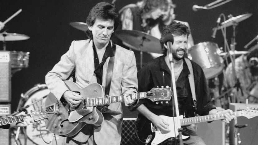 George Harrison (1943 - 2001, left) and Eric Clapton at Limehouse Studios in London during recording of the TV programme 'Blue Suede Shoes', spotlighting veteran rockabilly songwriter and guitarist Carl Perkins. In the background are drummers Slim Jim Phantom and Ringo Starr. (Photo by Dave Hogan/Hulton Archive/Getty Images)