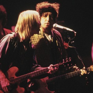 American singer-songwriters Tom Petty (left) and Bob Dylan with the band 'Traveling Wilburys', performing on stage in 1987. (Photo by Dave Hogan/Hulton Archive/Getty Images)