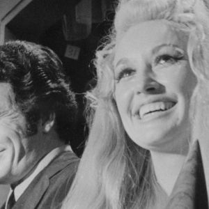 Merle Haggard and Dolly Parton standing side by side