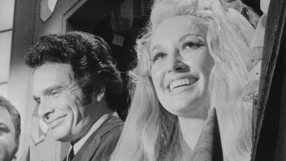 Merle Haggard and Dolly Parton standing side by side