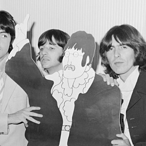 The Beatles Paul McCartney, Ringo Starr and George Harrison with a cardboard cut out of John Lennon from the film Yellow Submarine. July 1968. (Photo by Mirrorpix via Getty Images)