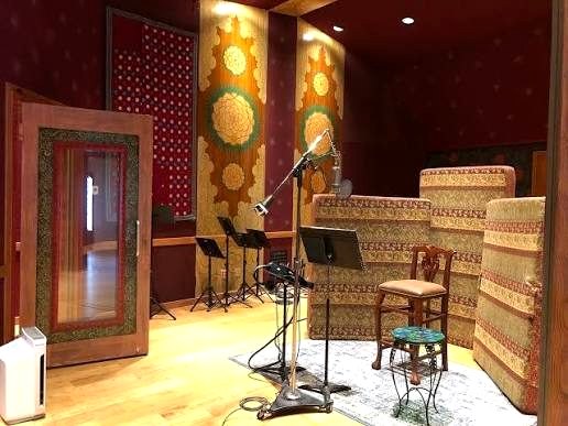 A studio room set up with microphones and music stands