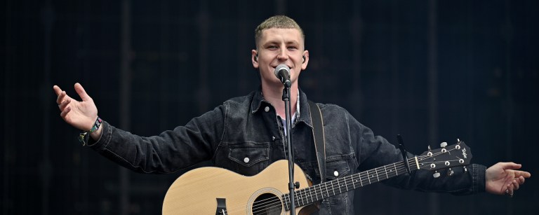 Nathan Evans, known for his rendition of The Wellerman, performs on stage with his guitar in Glasgow, Scotland.