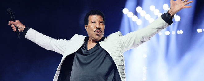 Lionel Richie onstage with arms outstretched